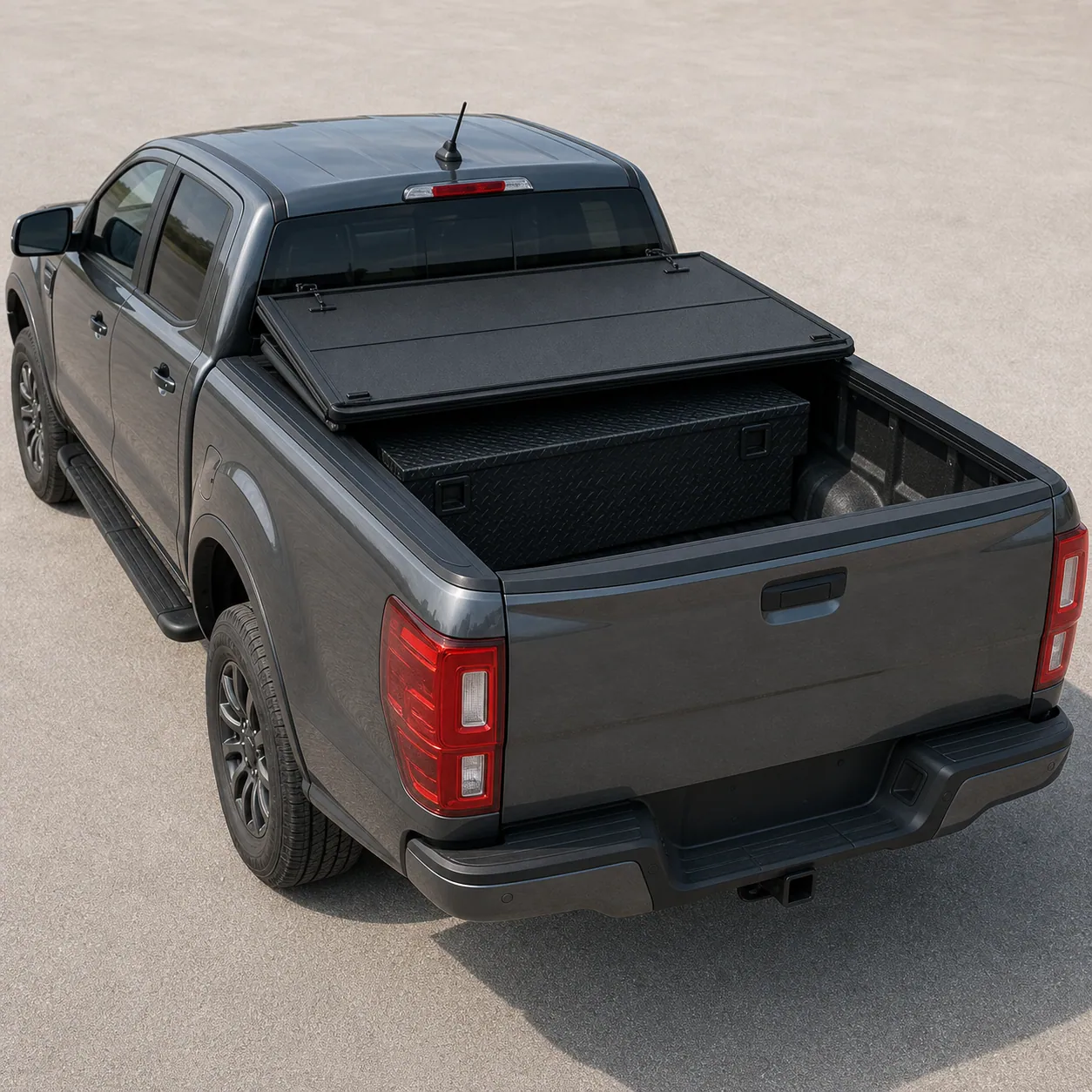Extang Solid Fold 2.0 hard tri-fold tonneau cover partly folded over a Ford Ranger bed with an under-bed tool box visible