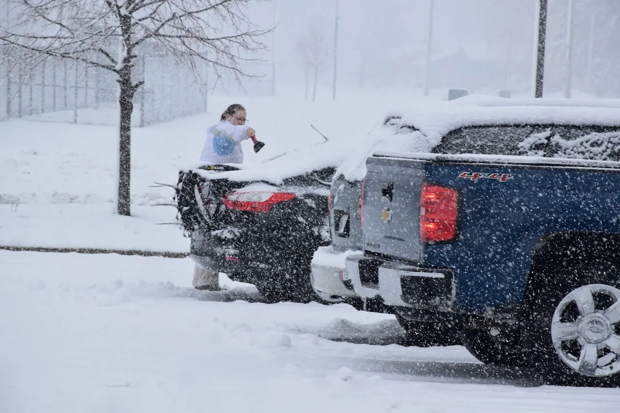 [Frost-covered black vinyl truck bed cover on a pickup parked in snow during winter]