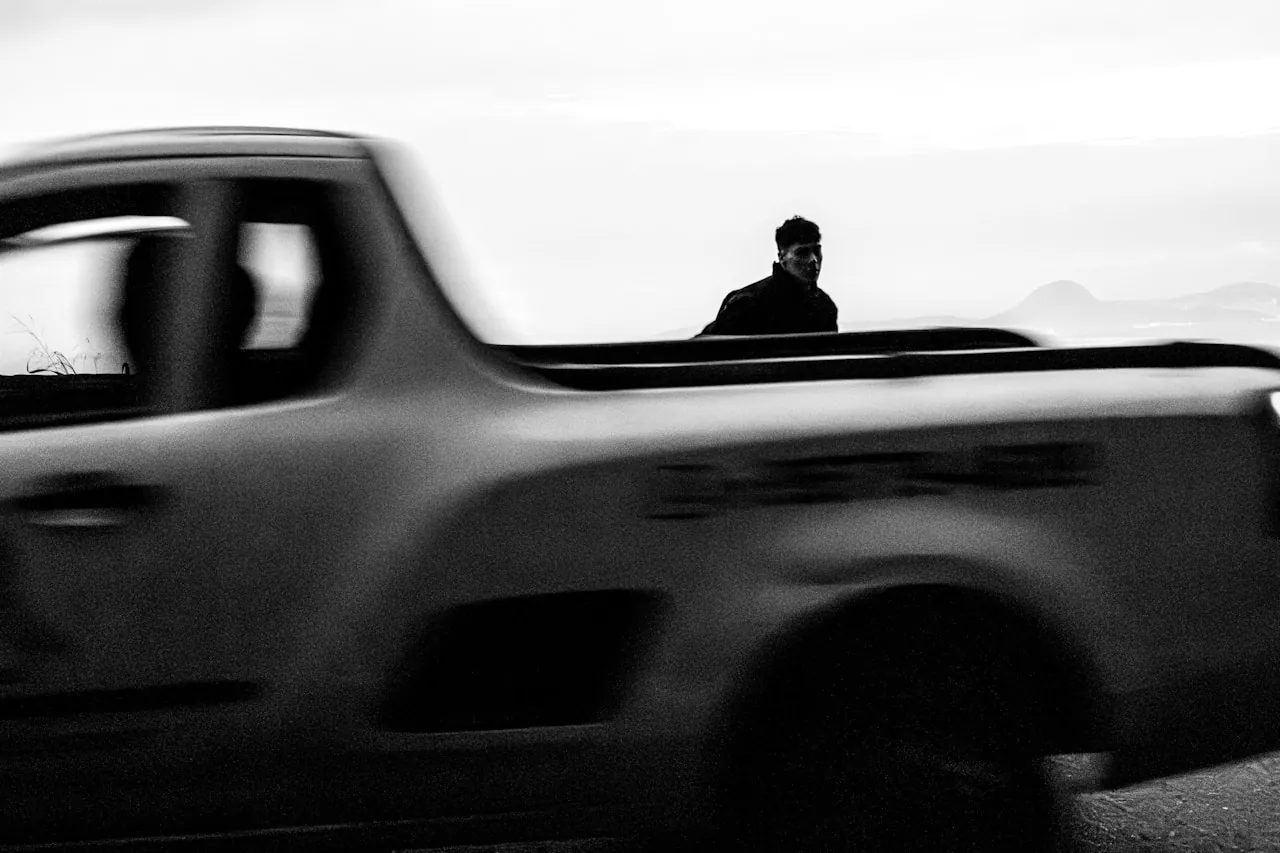 [Pickup truck driving on an open highway at speed with a closed tonneau cover over the bed]