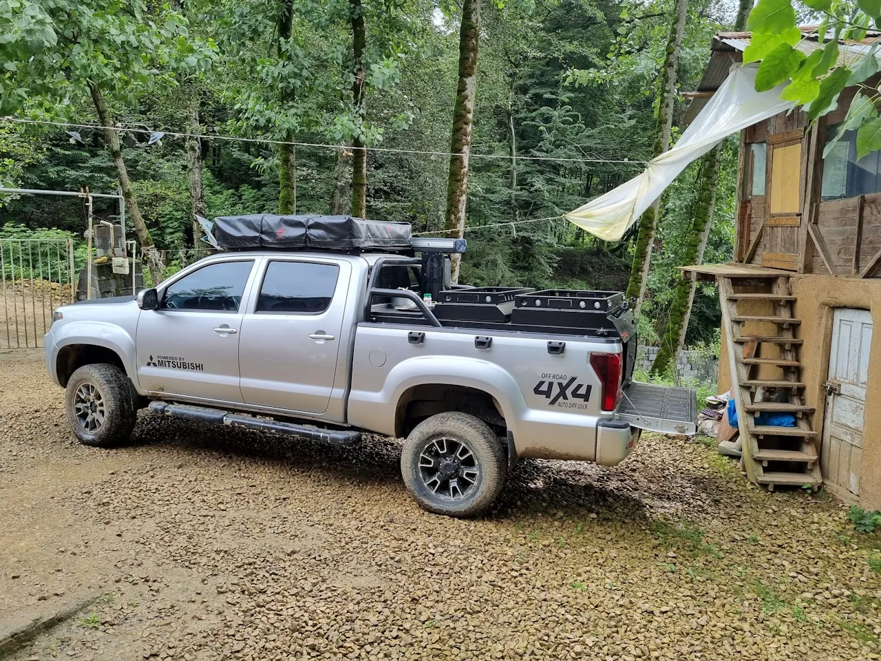 [Pickup truck with the bed cover rolled fully open, loaded with lumber and a ladder extending past the open tailgate]