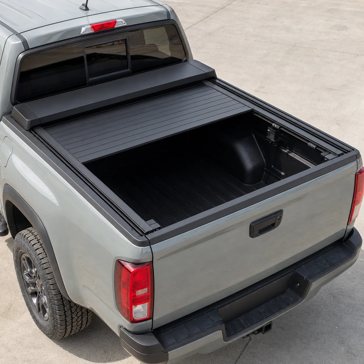 RetraxPRO XR retractable aluminum tonneau cover partly rolled open on a Chevy Colorado bed showing the slats and side rails