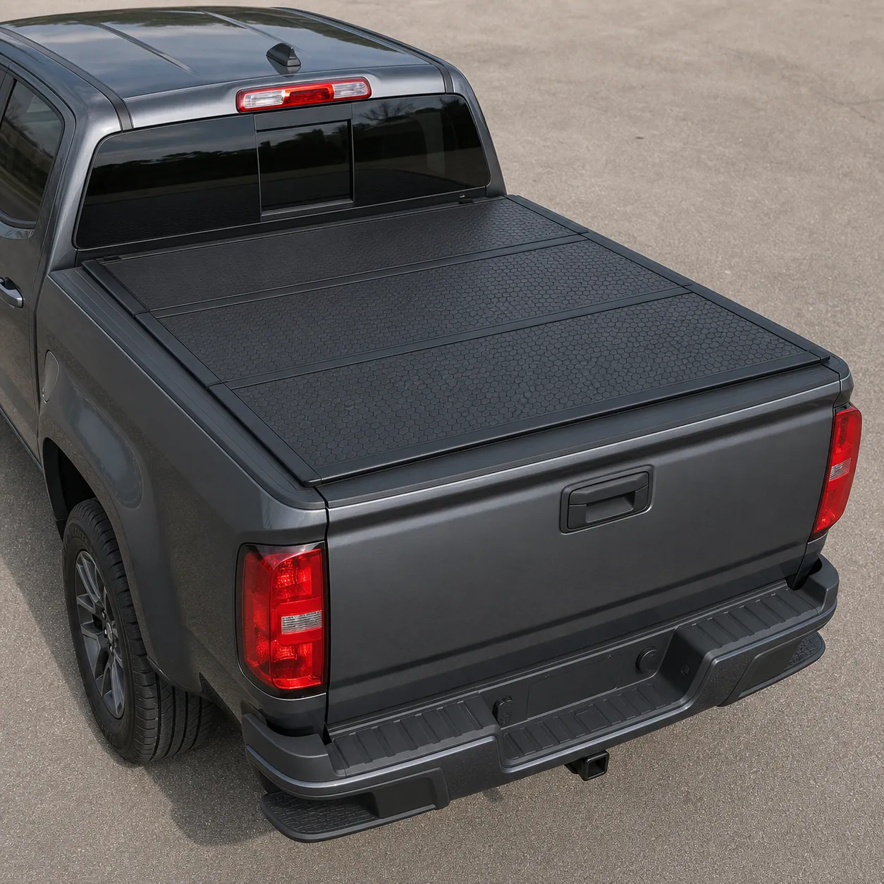 XTWEEX FRP hard tri-fold tonneau cover closed on a Chevy Colorado bed, matte black honeycomb panels